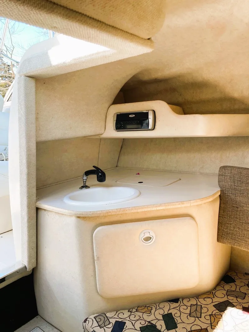 Slide: The Image of 2001 Sea Ray 225 Weekender cabin interior with sink and storage. - 14