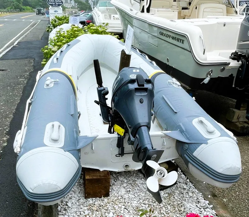 Slide: The Image of 2021 North Atlantic Inflatables ALA300 with Yamaha F8 motor displayed outdoors. - 2