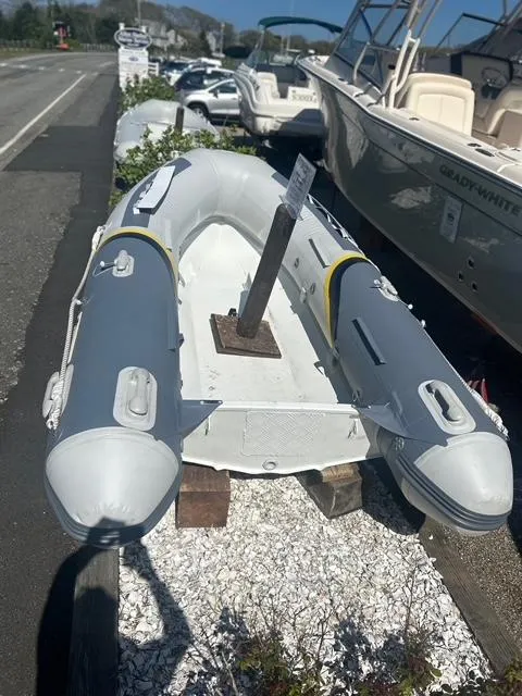 Slide: The Image of 2021 North Atlantic Inflatables ALA300 with Yamaha F8, displayed outdoors on gravel. - 6