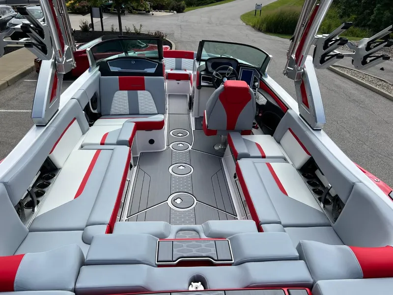 Slide: The Image of 2023 MasterCraft X24 boat interior with red and gray seating, spacious layout, and modern design. - 12
