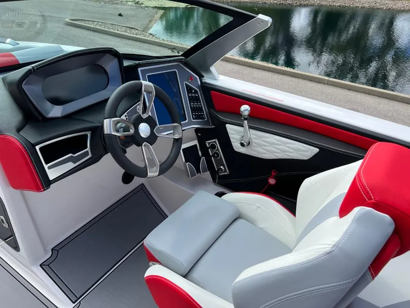 Slide: The Image of 2023 MasterCraft X24 boat interior with modern steering and dashboard, featuring red and white seating. - 9