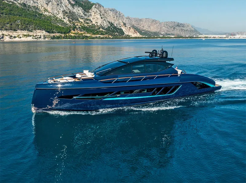 The Image of 2023 Lazzara LSX 67 yacht cruising on clear blue waters near rocky coastline. - 0