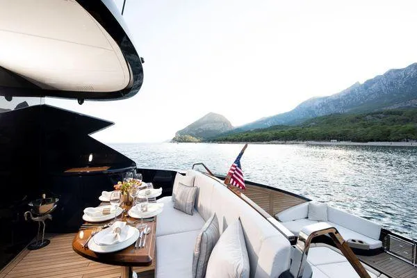 Slide: The Image of Luxurious 2023 Lazzara LSX 67 yacht with elegant dining setup and scenic ocean view. - 26