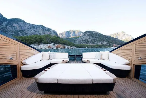Slide: The Image of Luxurious 2023 Lazzara LSX 67 yacht deck with plush seating, scenic mountain backdrop. - 6