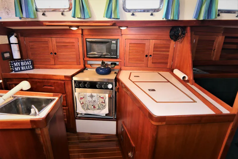 Slide: The Image of 1998 Tartan 4100 yacht kitchen with wood cabinetry, stove, and sink. - 12