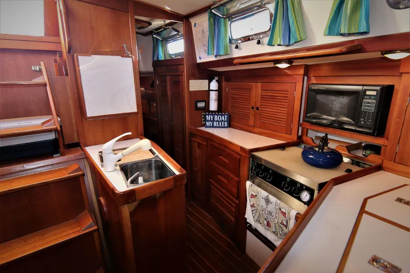 Slide: The Image of Interior of 1998 Tartan 4100 sailboat kitchen with wood cabinetry and appliances. - 13