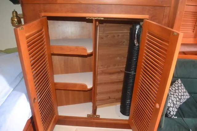 Slide: The Image of Open wooden cabinet with shelves inside a 1998 Tartan 4100 boat interior. - 18
