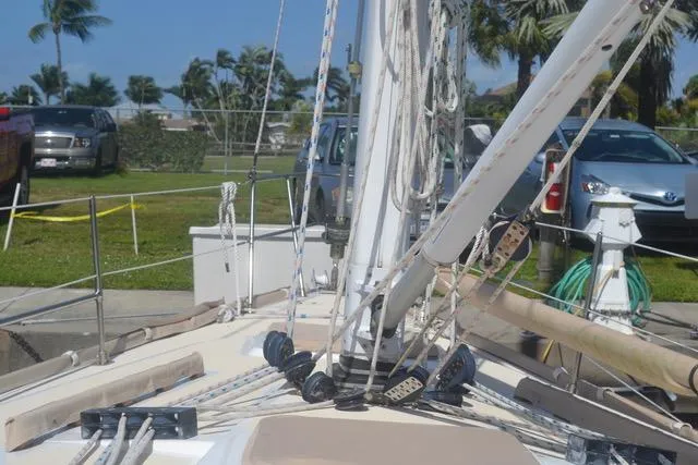 Slide: The Image of Sailboat deck view of 1998 Tartan 4100, docked with visible rigging and parked cars nearby. - 19