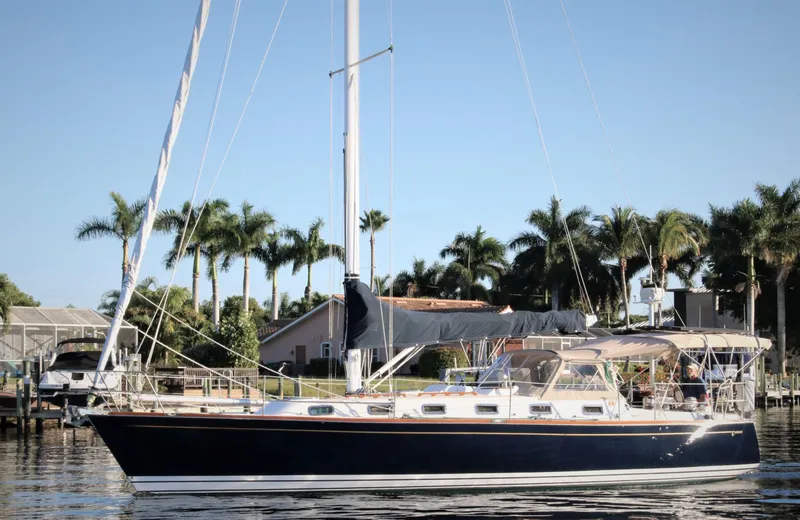 Slide: The Image of Sailboat Tartan 4100, 1998 model, docked near palm trees under clear blue sky. - 2