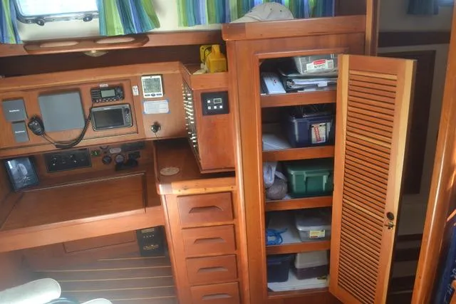 Slide: The Image of Interior of a 1998 Tartan 4100 sailboat with navigation equipment and storage shelves. - 22