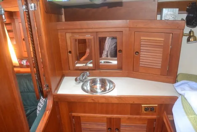 Slide: The Image of 1998 Tartan 4100 yacht interior with wooden cabinetry and stainless steel sink. - 25