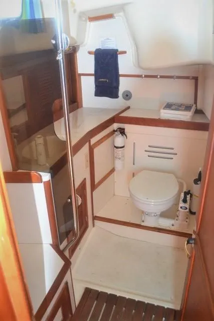 Slide: The Image of 1998 Tartan 4100 yacht bathroom with wooden accents and compact design. - 26