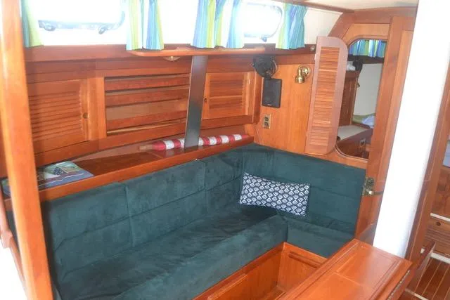 Slide: The Image of Interior of 1998 Tartan 4100 sailboat with green seating and wooden cabinetry. - 3