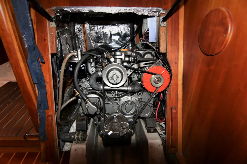 Slide: The Image of Engine compartment of a 1998 Tartan 4100 sailboat, showcasing mechanical components and wooden paneling. - 31