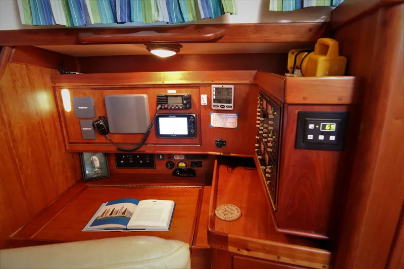 Slide: The Image of Navigation station inside a 1998 Tartan 4100 sailboat with control panels and equipment. - 46