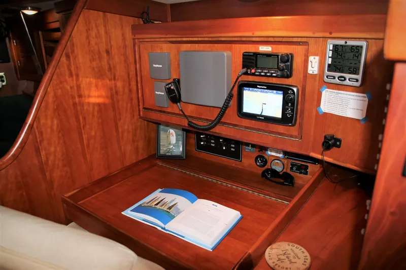 Slide: The Image of Navigation station on a 1998 Tartan 4100 sailboat with communication equipment and open book. - 8
