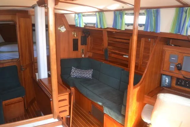 Slide: The Image of Interior of 1998 Tartan 4100 sailboat with wooden furnishings and green seating. - 9