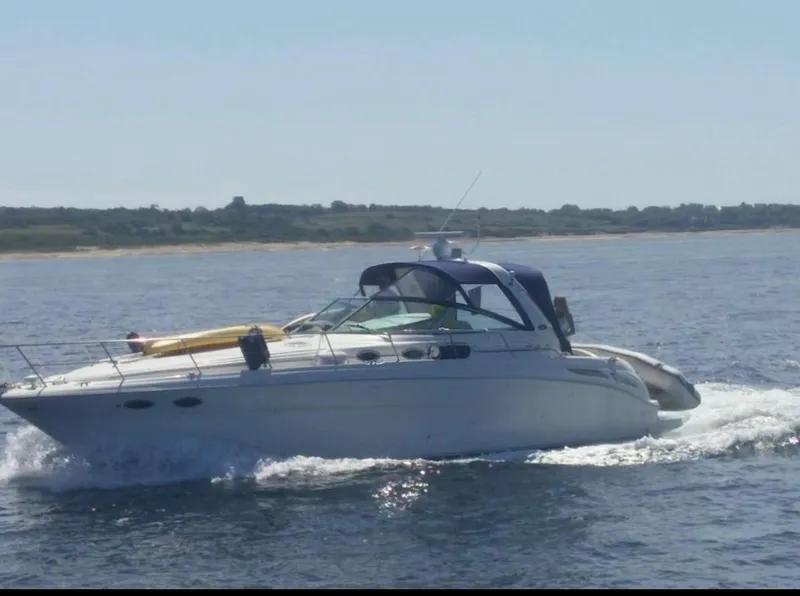 Slide: The Image of 2001 Sea Ray 380 Sundancer cruising on open water under clear skies. - 10