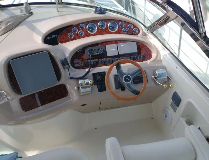 Slide: The Image of 2001 Sea Ray 380 Sundancer helm with wood accents and modern controls. - 12