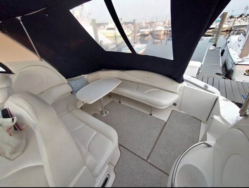 Slide: The Image of 2001 Sea Ray 380 Sundancer interior with seating and table, docked at marina. - 7