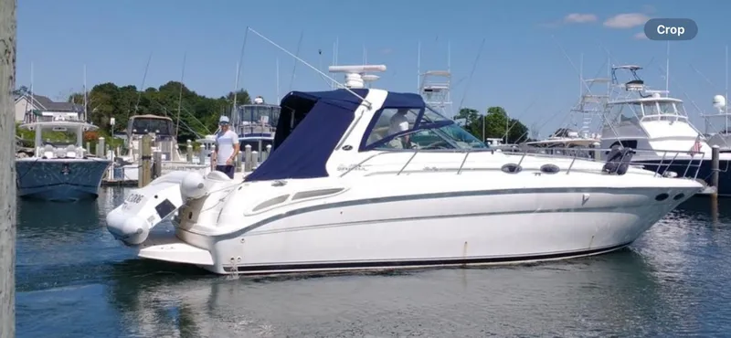 Slide: The Image of 2001 Sea Ray 380 Sundancer yacht docked in a marina under clear blue skies. - 9