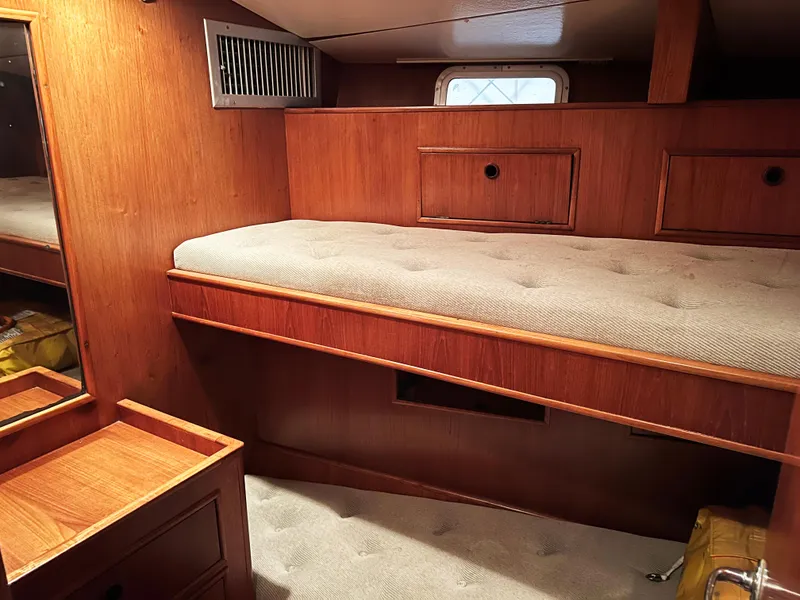 Slide: The Image of Cozy cabin interior of 1987 Oyster 46.5 yacht with wooden furnishings and a single bed. - 14