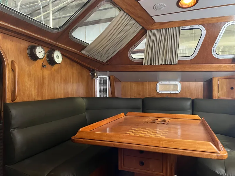 Slide: The Image of Interior of 1987 Oyster 46.5 yacht with wood paneling and leather seating. - 17