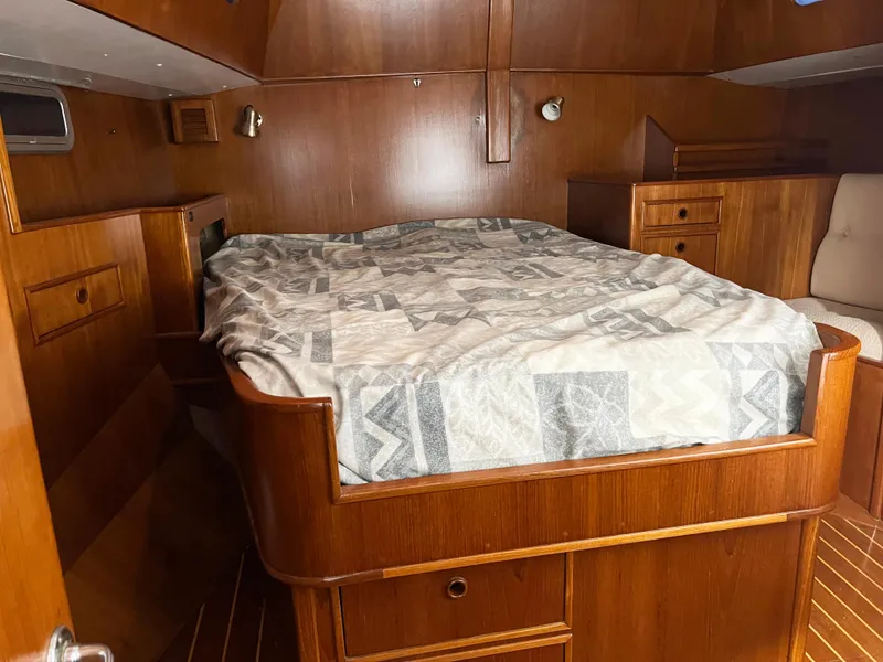Slide: The Image of Cozy cabin interior of 1987 Oyster 46.5 yacht with wooden furnishings and bed. - 22