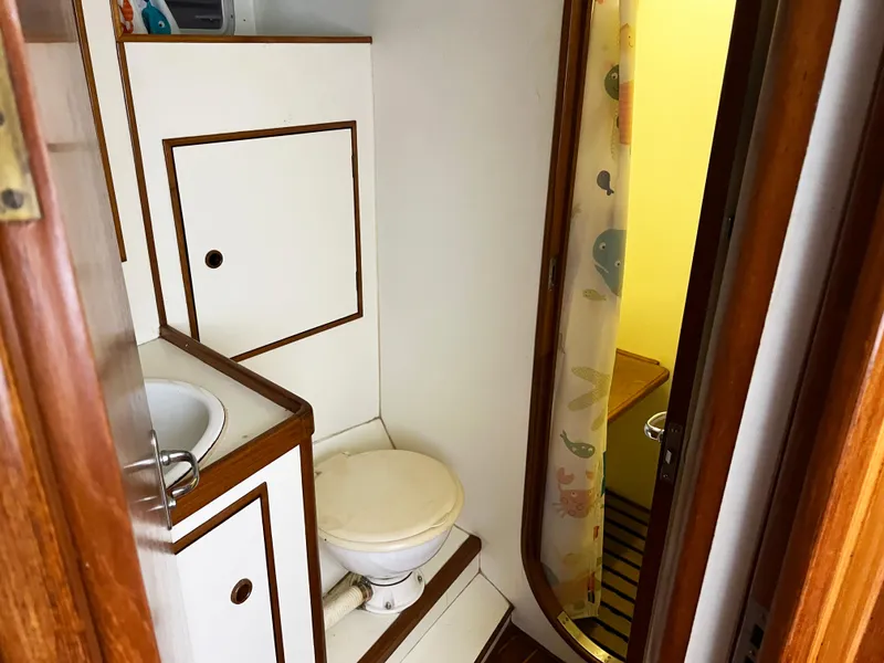 Slide: The Image of 1987 Oyster 46.5 yacht bathroom with wooden trim and compact design. - 25