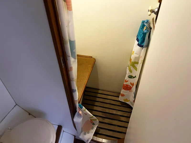 Slide: The Image of Bathroom interior of 1987 Oyster 46.5 yacht with nautical-themed shower curtain. - 27