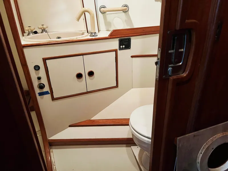 Slide: The Image of 1987 Oyster 46.5 yacht bathroom with sink, toilet, and wooden accents. - 28