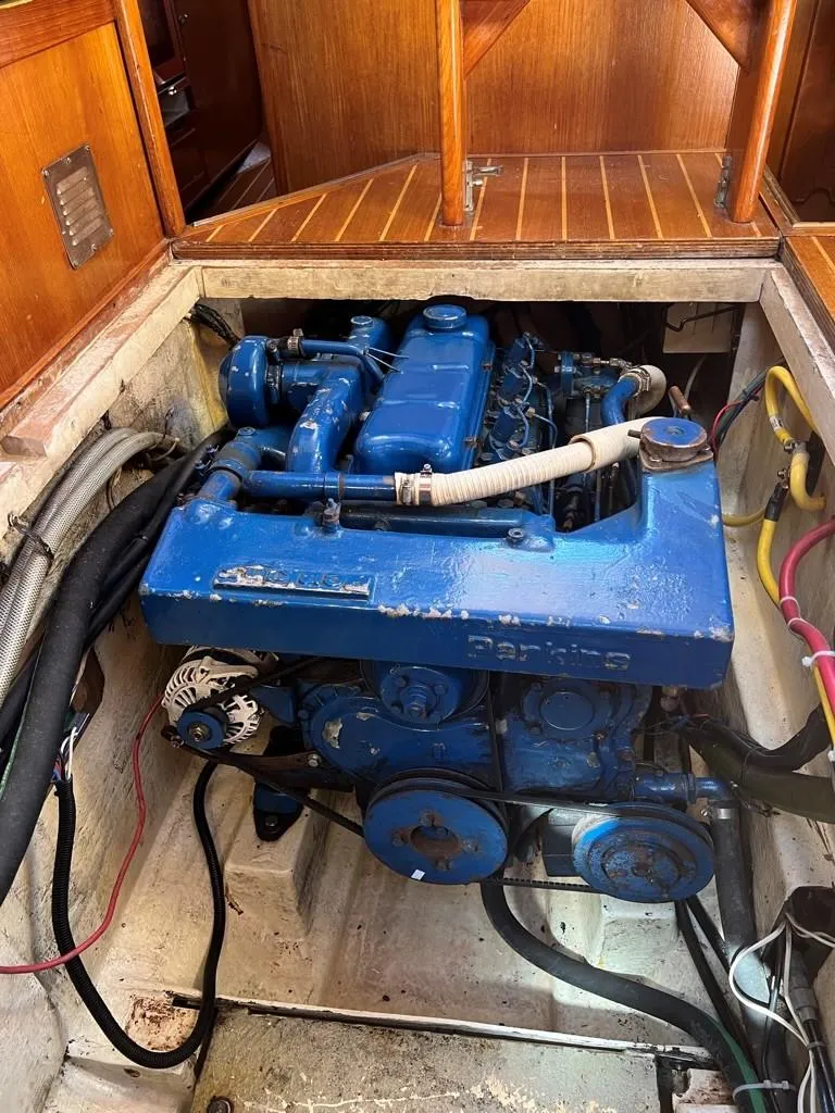 Slide: The Image of 1987 Oyster 46.5 sailboat engine compartment with blue engine and wiring. - 34