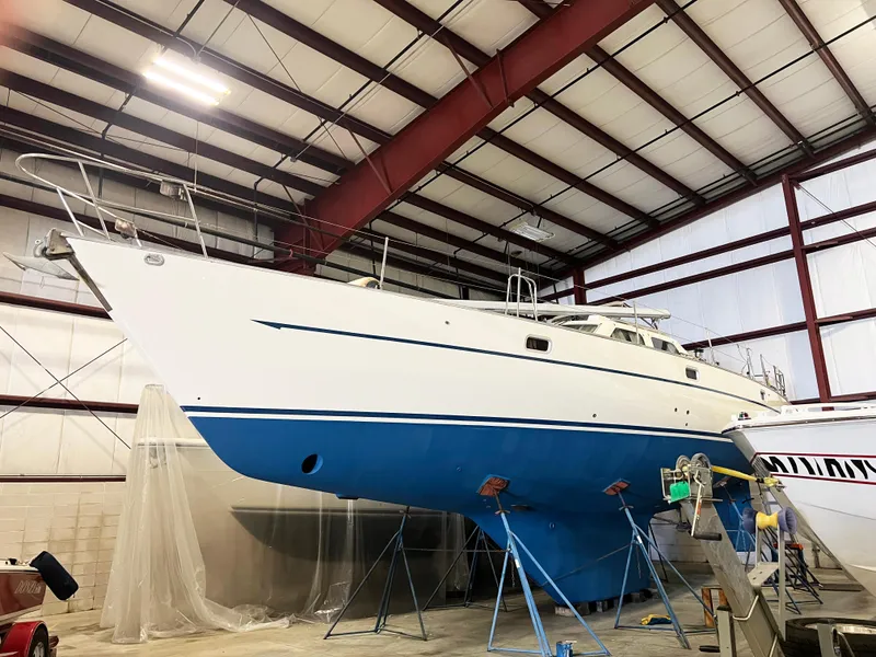Slide: The Image of 1987 Oyster 46.5 sailboat in a warehouse, elevated on stands for maintenance. - 37