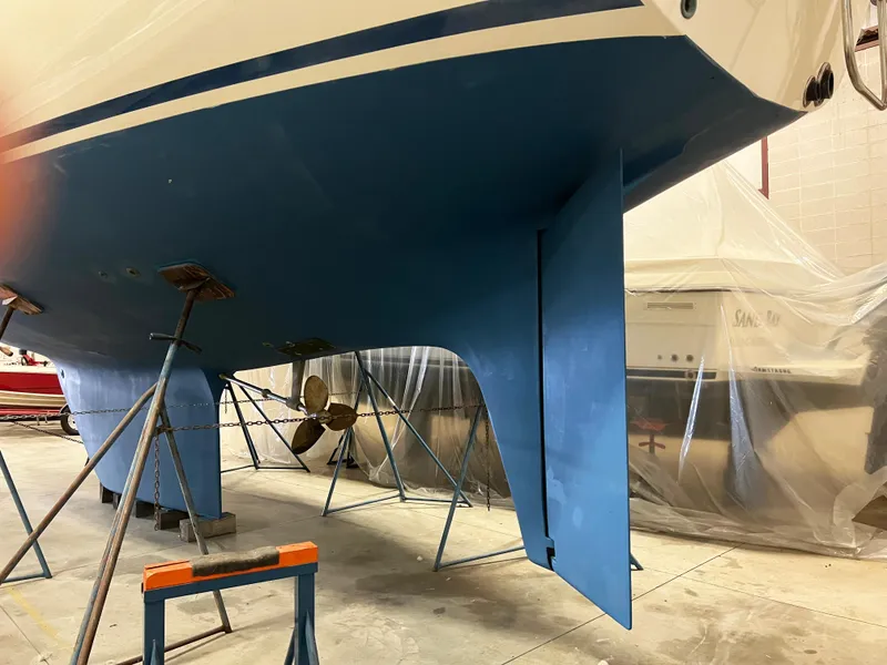 Slide: The Image of Oyster 46.5 sailboat from 1987 in a workshop, showing hull and propeller. - 39