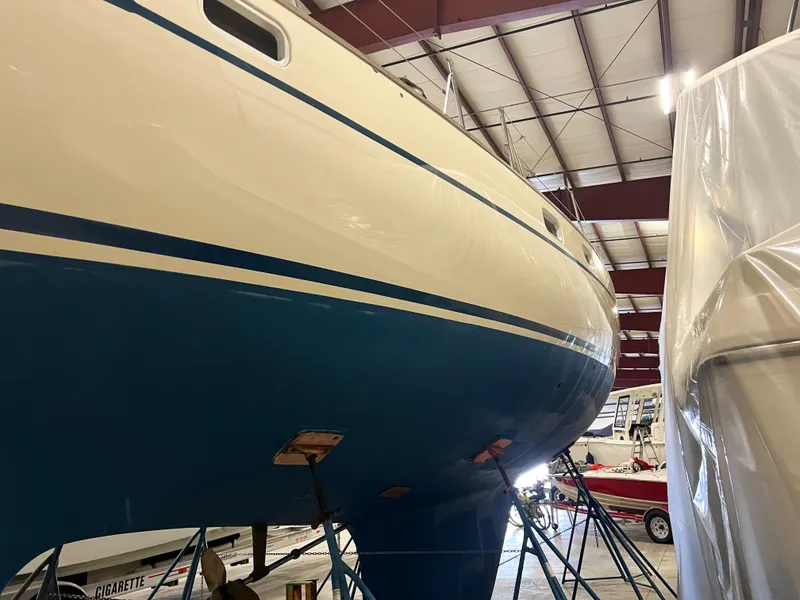 Slide: The Image of Oyster 46.5 sailboat from 1987 in indoor storage, blue and white hull. - 43