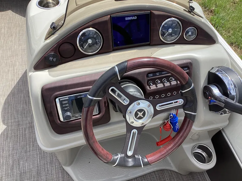 Slide: The Image of Steering console of 2018 Berkshire 23RFX STS 2.0 boat with wood accents and navigation controls. - 8