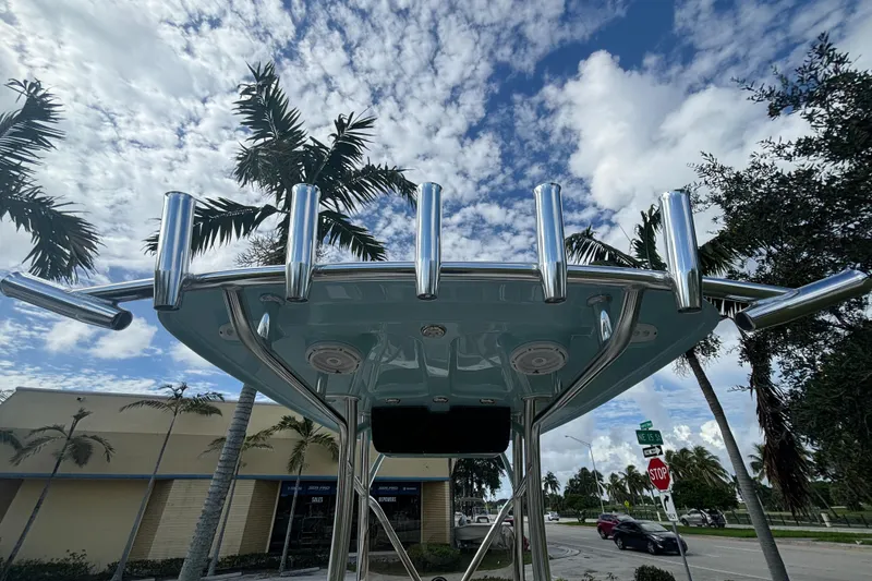 Slide: The Image of 2025 Pioneer 202 Sportfish boat with rod holders, under a partly cloudy sky. - 17