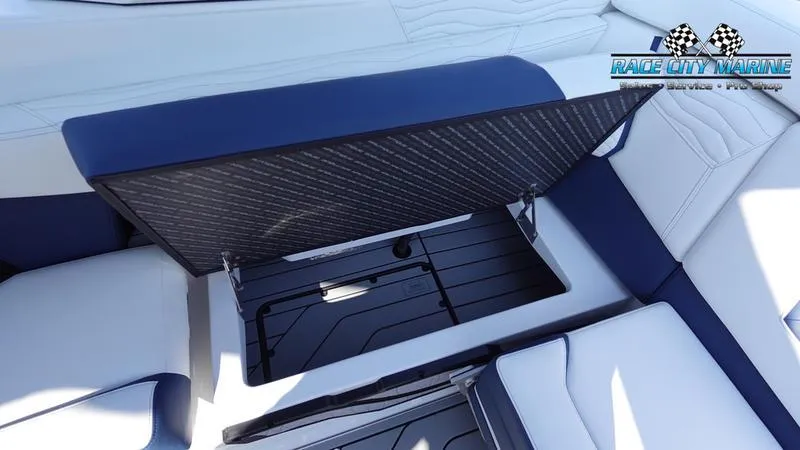 Slide: The Image of 2025 Nautique Super Air Nautique G23 boat storage compartment, open view, Race City Marine logo. - 34