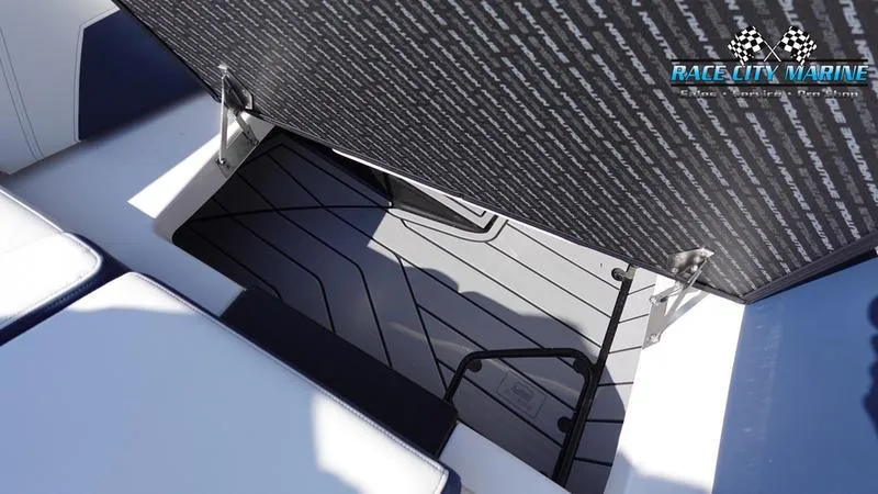 Slide: The Image of 2025 Nautique Super Air Nautique G23 storage compartment with Race City Marine branding. - 37
