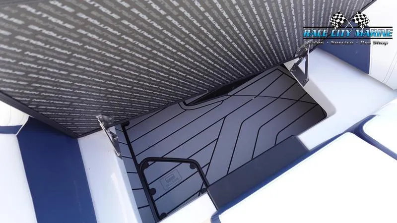 Slide: The Image of 2025 Nautique Super Air Nautique G23 storage compartment with Race City Marine branding. - 40