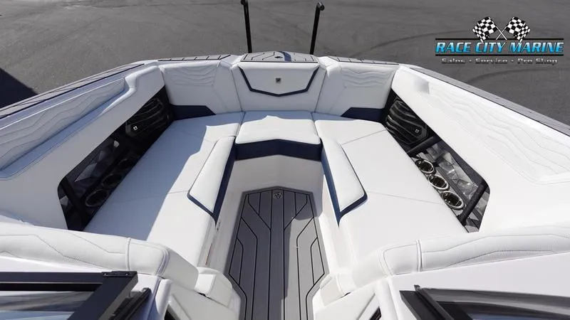 Slide: The Image of 2025 Nautique Super Air Nautique G23 boat interior with white seating and cup holders. - 47
