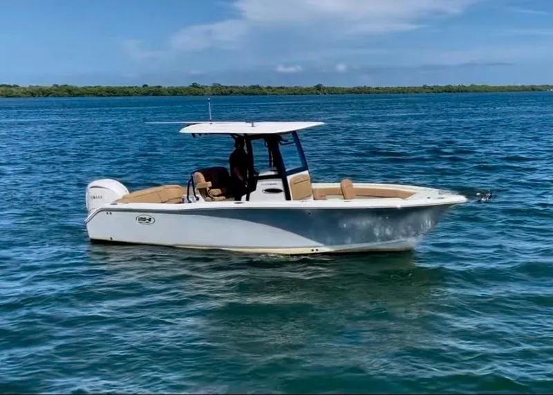 Slide: The Image of 2023 Sea Hunt Ultra 255 SE boat on calm blue water. - 0