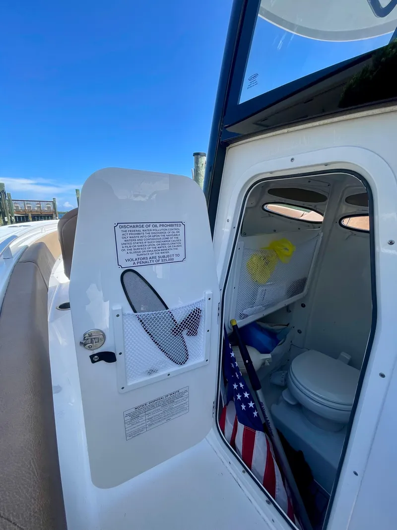 Slide: The Image of 2023 Sea Hunt Ultra 255 SE boat interior with open storage compartment and American flag. - 12