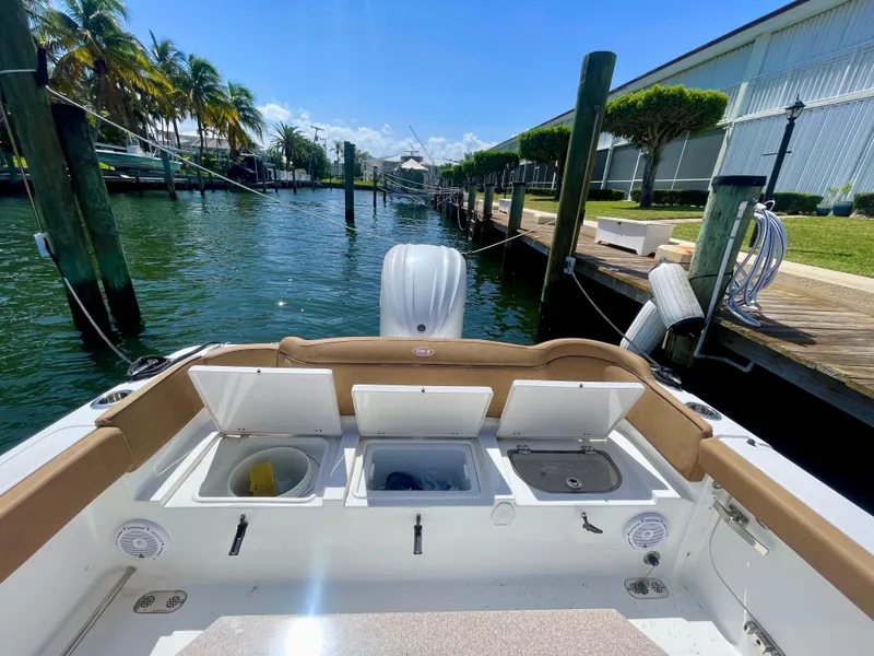 Slide: The Image of 2023 Sea Hunt Ultra 255 SE boat docked by a sunny canal. - 14