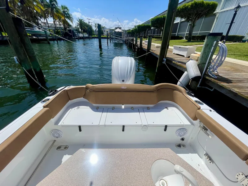 Slide: The Image of 2023 Sea Hunt Ultra 255 SE boat docked in a scenic marina. - 15