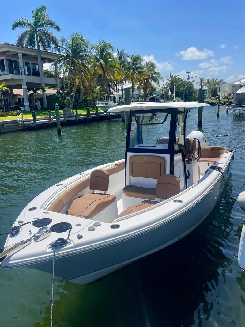 Slide: The Image of 2023 Sea Hunt Ultra 255 SE boat docked in sunny waterfront setting. - 19