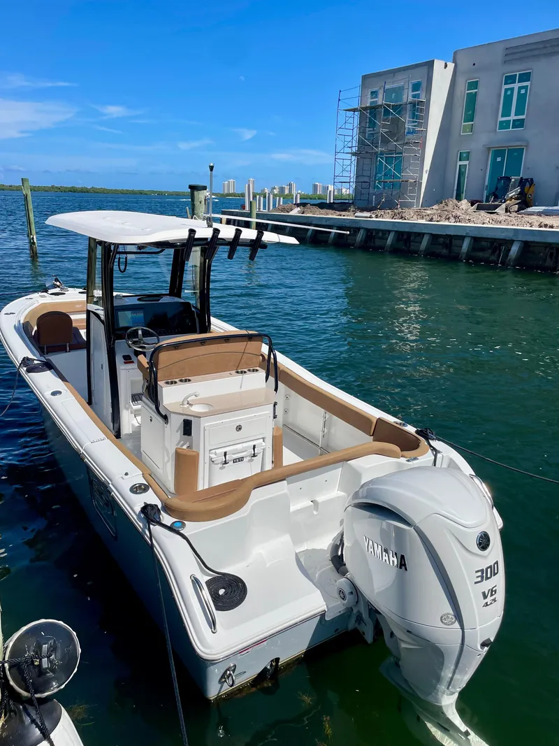 Slide: The Image of 2023 Sea Hunt Ultra 255 SE boat docked by waterfront property. - 21