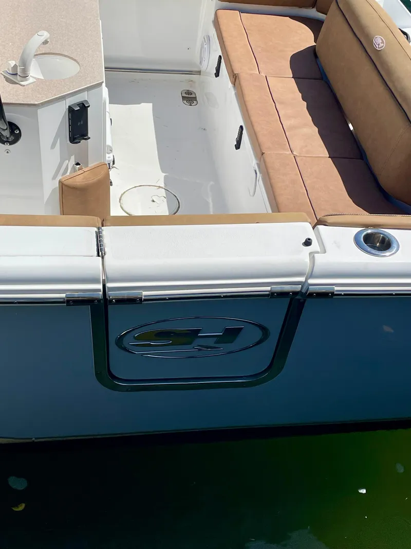 Slide: The Image of 2023 Sea Hunt Ultra 255 SE boat with tan seating and sleek design. - 22