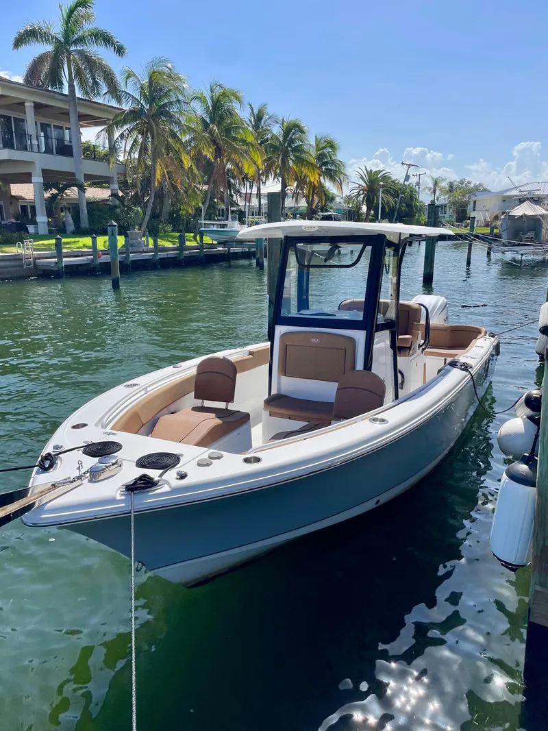 Slide: The Image of 2023 Sea Hunt Ultra 255 SE boat docked in sunny marina. - 23