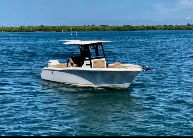 Slide: The Image of 2023 Sea Hunt Ultra 255 SE boat on calm blue water. - 24